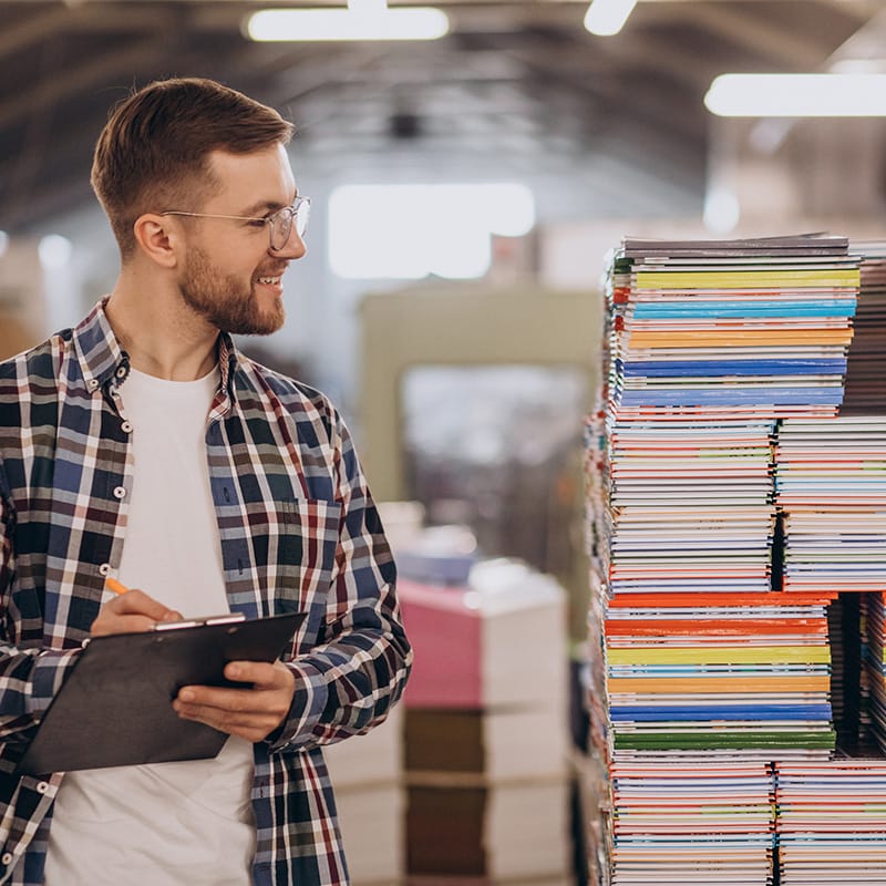 Man working in printing house with paper and paints druk katalogów reklamowych drukarnia Rzeszów Maddruk